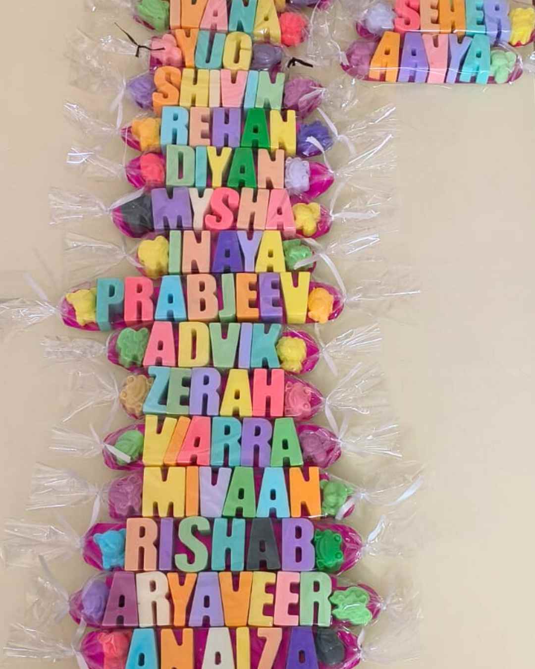 Flatlay of multiple kids names soaps packed in toffee style gift wrap