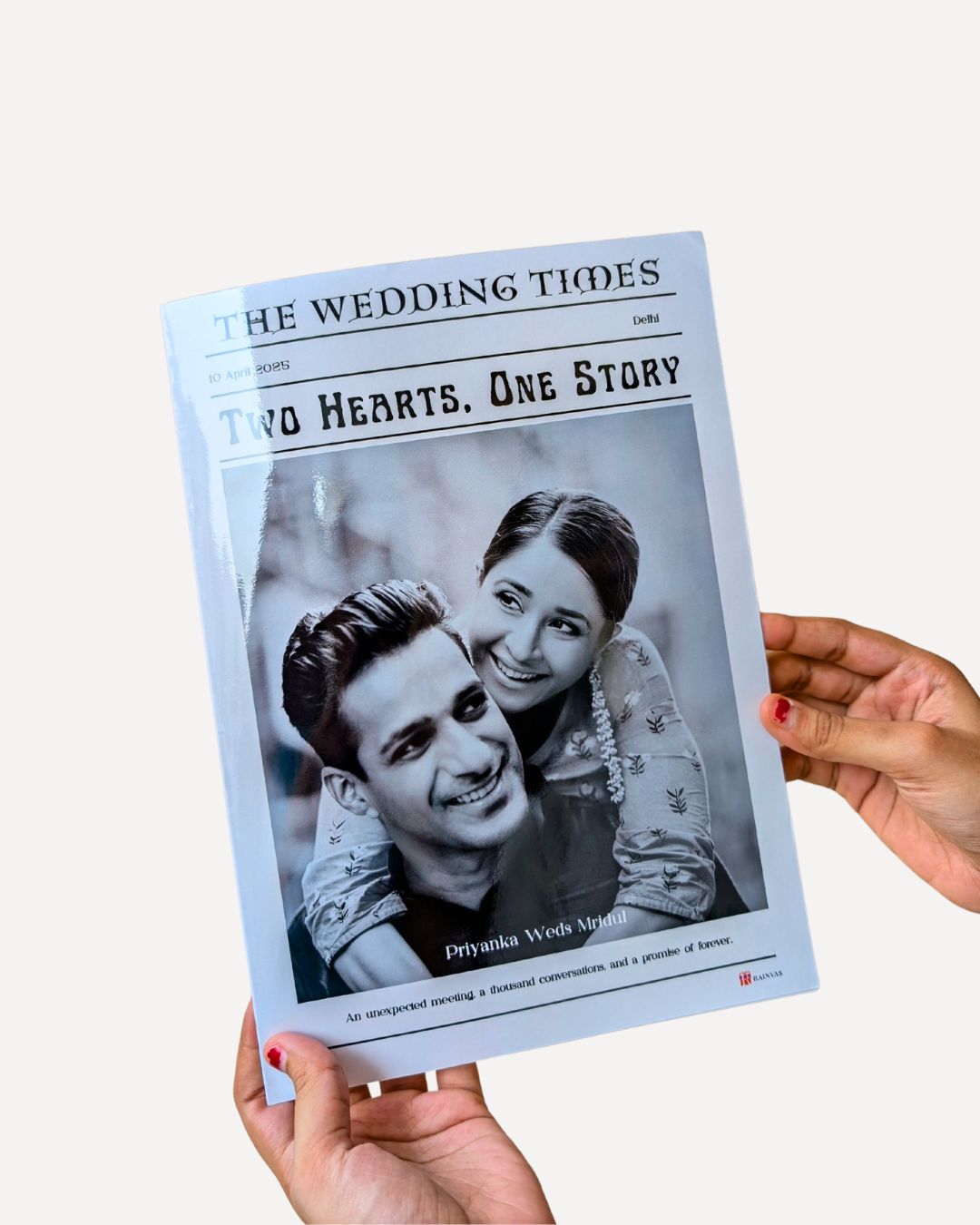Hand holding a magazine titled 'The Wedding Times' with a black and white photo of a couple on the cover.