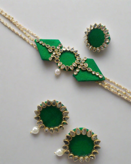 Green choker and earrings embellished with kundan and white pearl beads.
