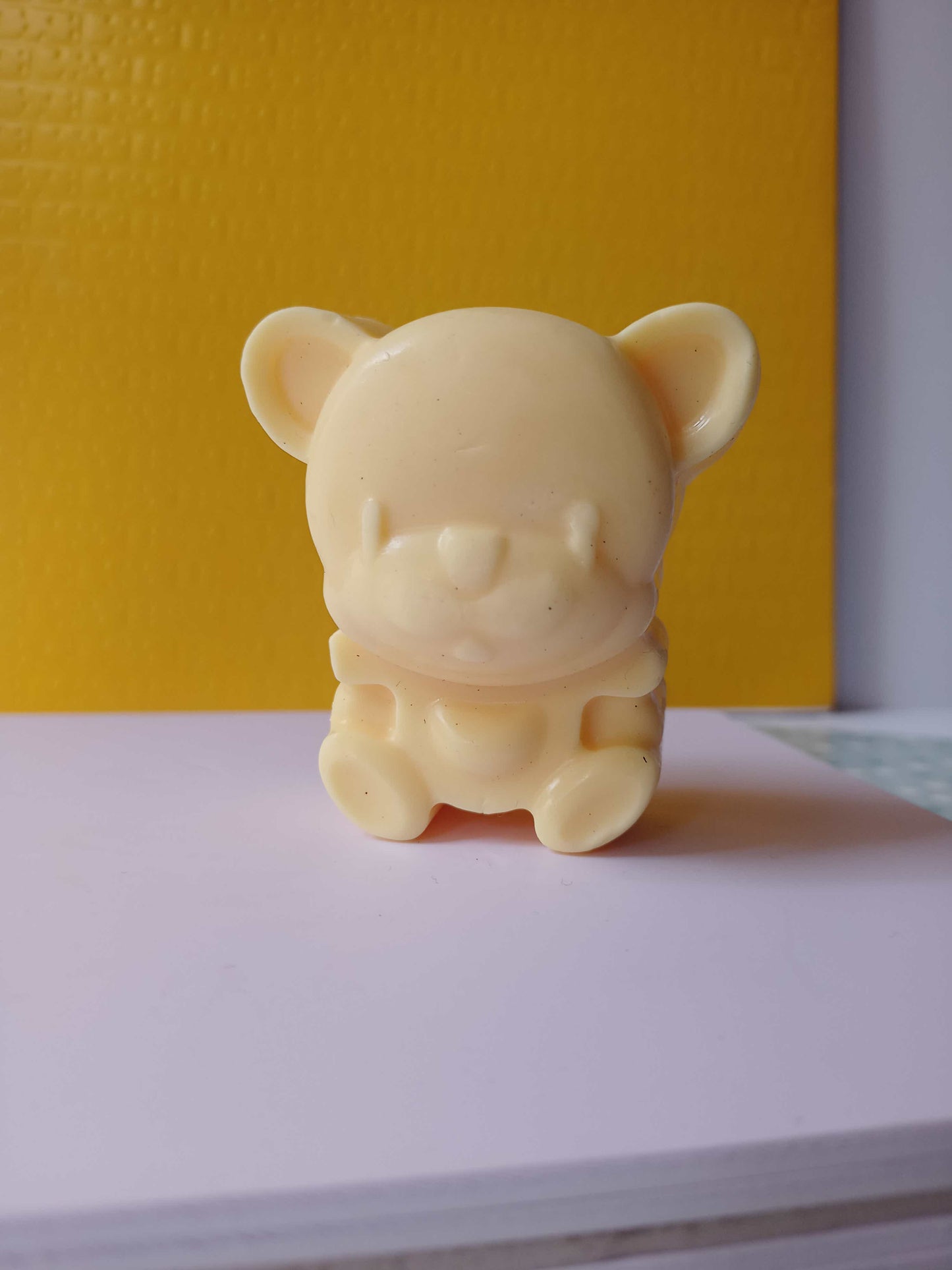 yellow beige color teddy shaped soap on a white backdrop