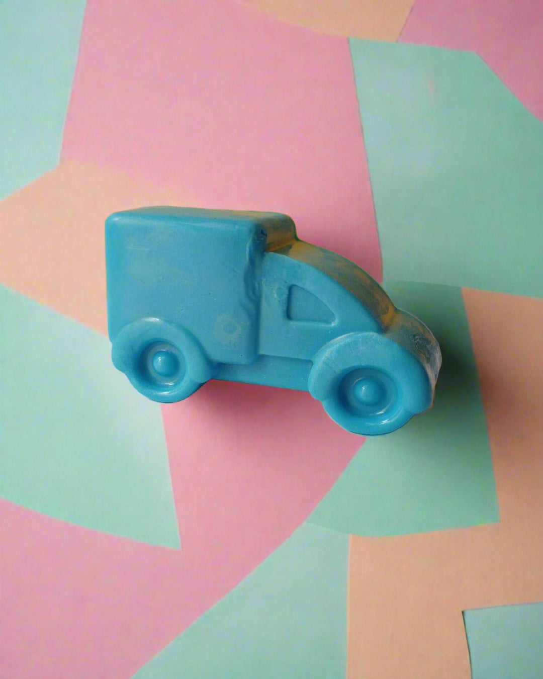 Blue truck shaped soap on yellow white backdrop
