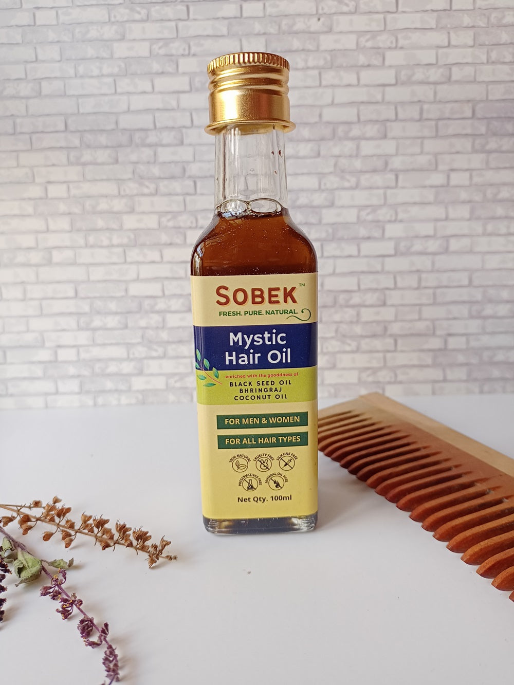 Sobek naturals mystic oil with brown box and leaves in background placed on white backdrop
