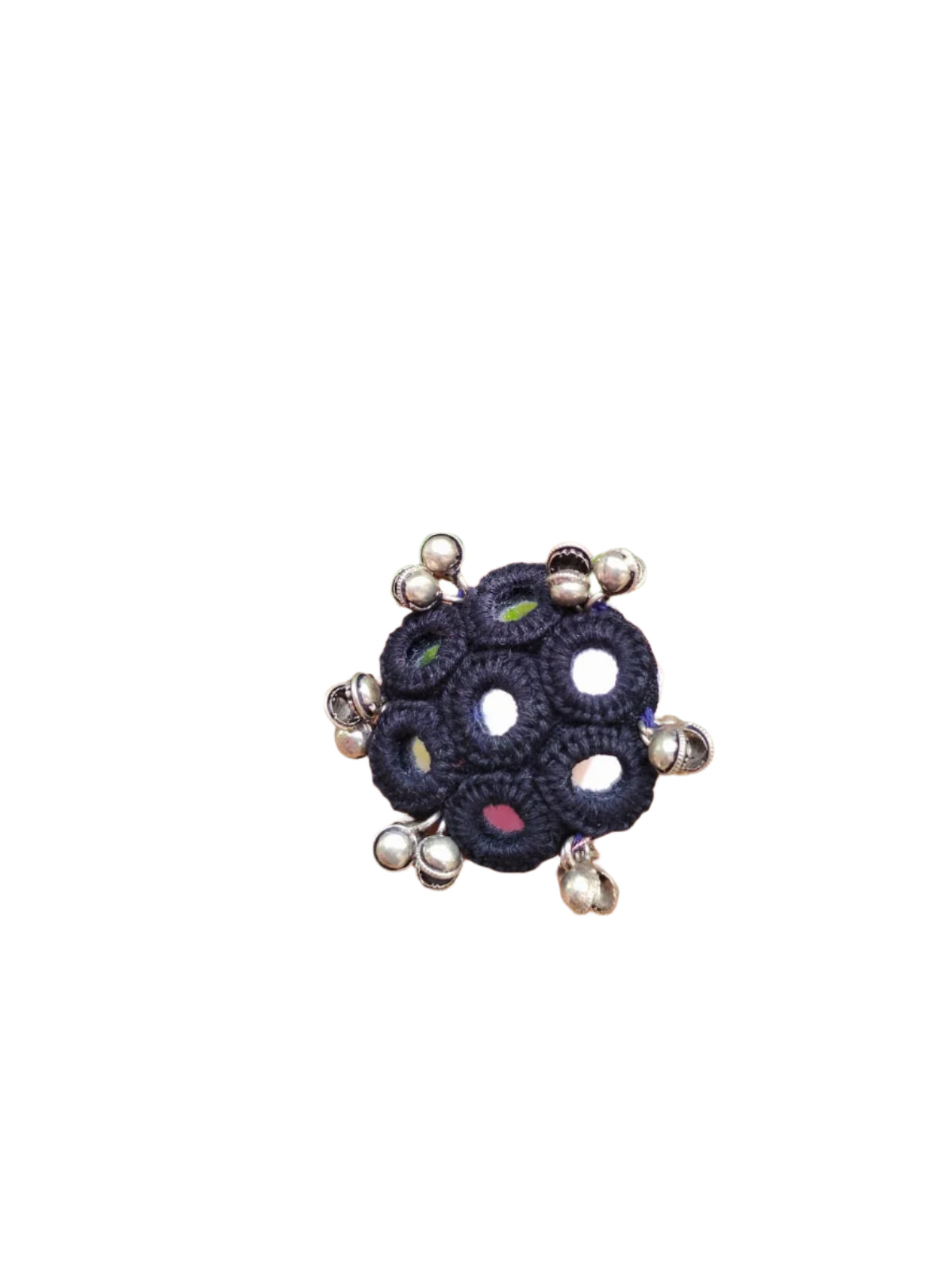 Hand wearing a decorative ring with green foliage in the background
