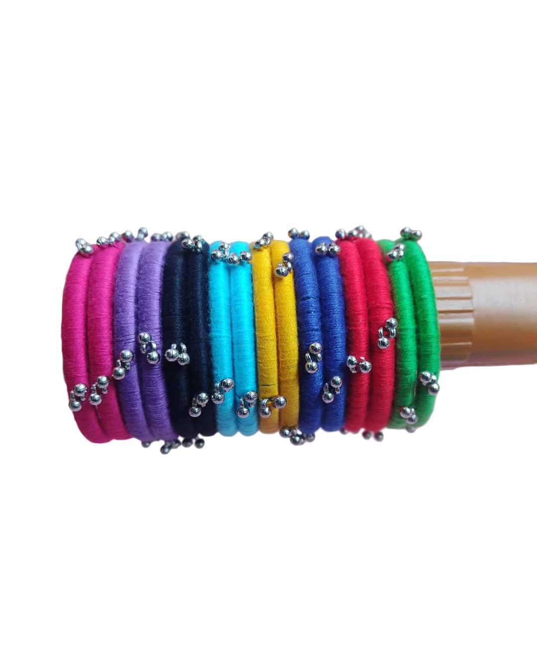 Multi color bangles on wooden stick on a pink backdrop