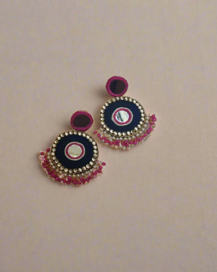 Dark pink and black mirror round earrings with beads and kundan on border on a white backdrop
