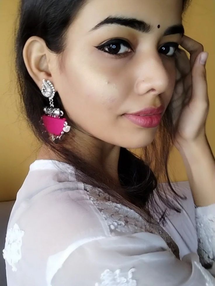 Indian girl left profile wearing white kurti and pink semi round earrings with silver charm