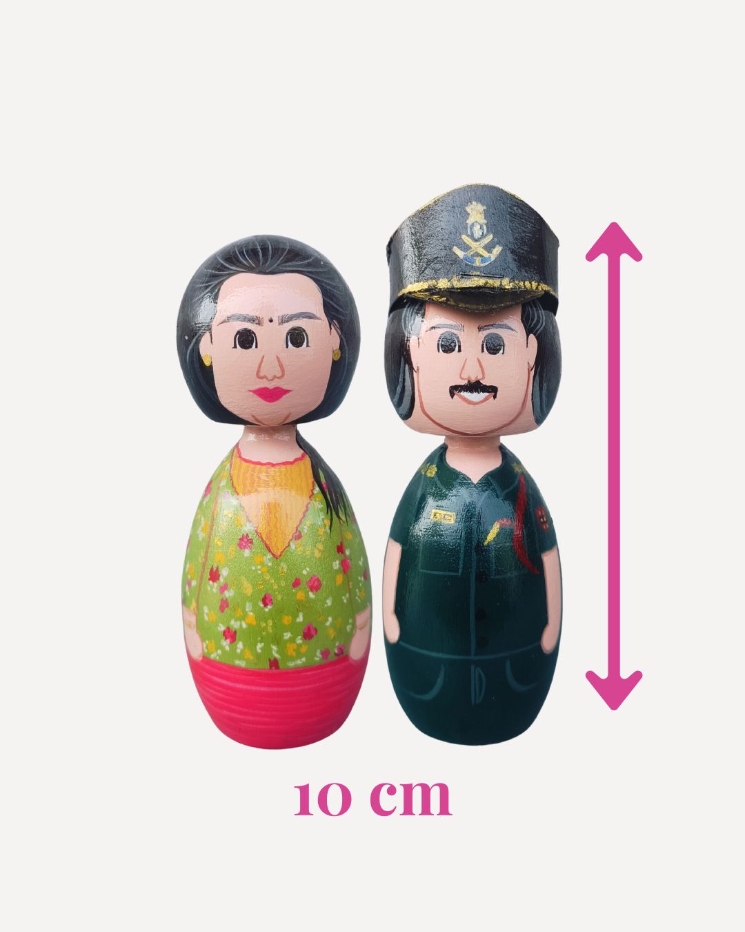 Two dolls, one in civilian clothing and the other in a military uniform, with a measurement indicator showing their height.
