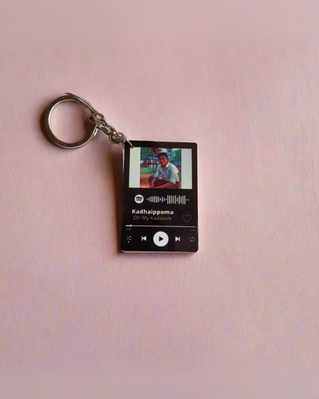 Black and white spotify keychain with happy boy's picture on it