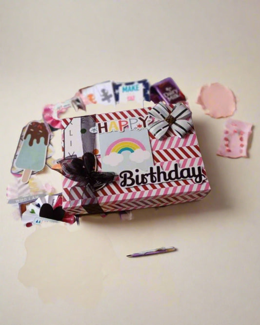 Flat lay of a birthday hamper loaded with photos and cards and decorated with ribbons