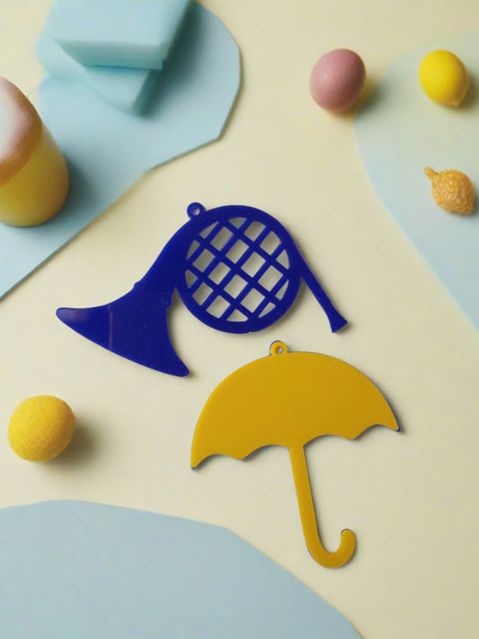 yellow umbrella and blue french horn miniature keychain on white backdrop