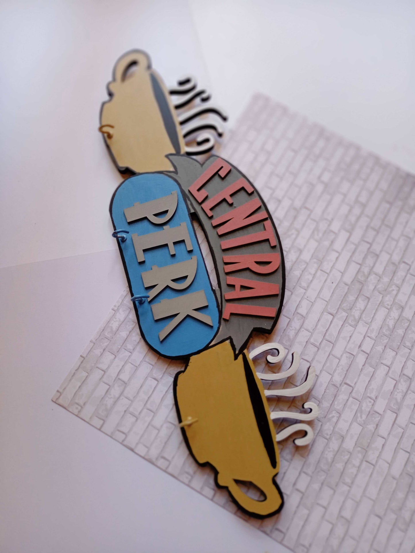 Friends TV central perk logo keyholder in pastel colors on a white base