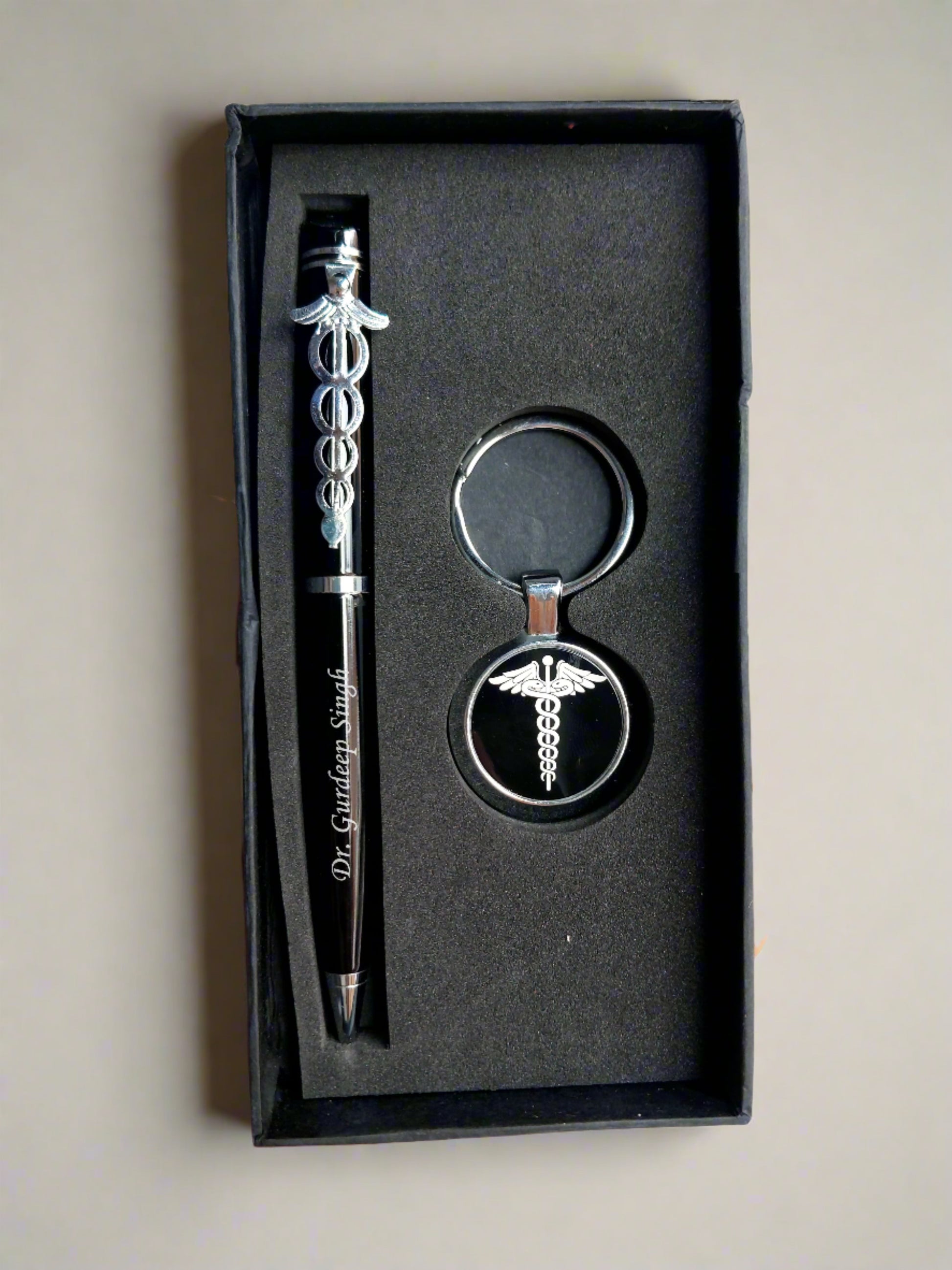 Hand holding Black box with pen and doctor keychain inside 