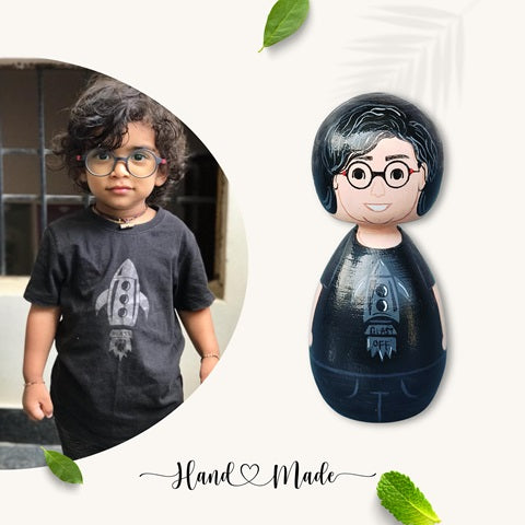 Wooden peg doll of a kid wearing black tshirt and glasses with reference image on the left