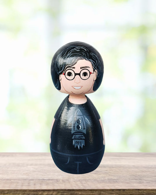 Wooden handmade peg doll of a boy wearing black outfit 
