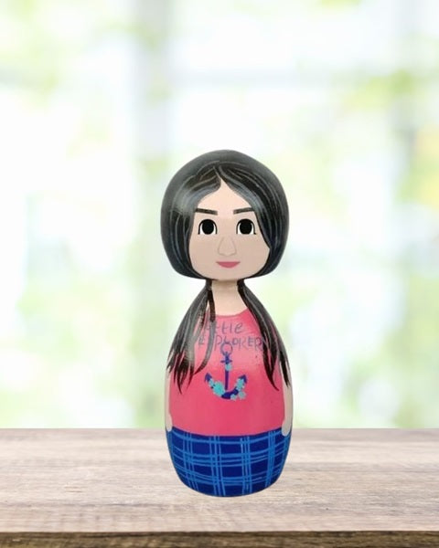 Wooden peggy doll of a girl wearing red tshirt and blue pants