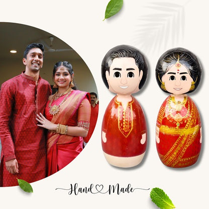 Wooden peggy doll of a bride and groom couple with reference image on left wearing red outfits