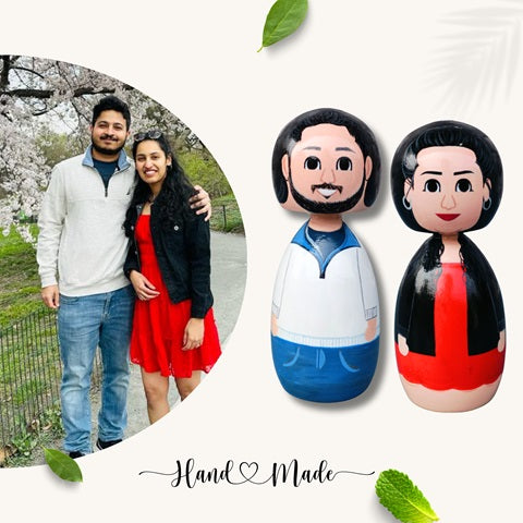 Wooden peg dolls of a couple wearing tshirt and jeans and girl wearing red dress 