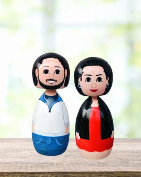 Wooden miniature dolls handpainted of a couple wearing white and red outfits