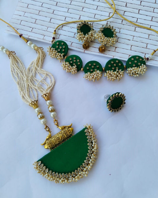 Dark green necklace, earrings, choker, ring with golden beads and tabiz on white backdrop