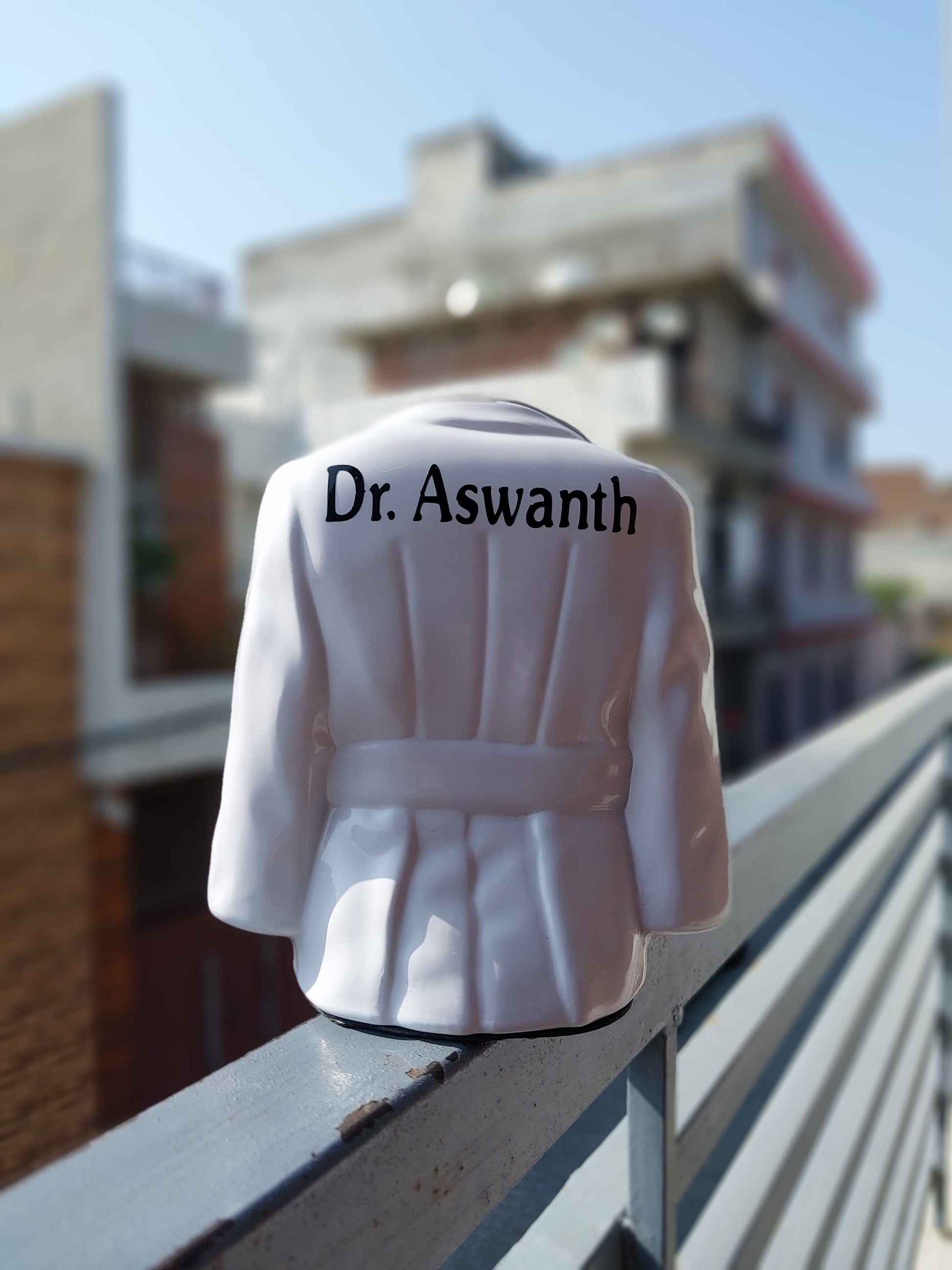 White Doctor's apron shaped pen stand with male name at back