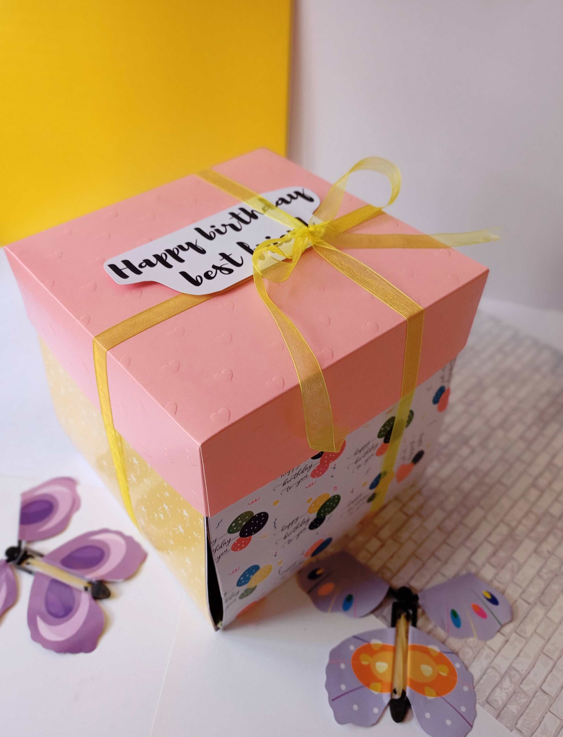 Colorful gift box with pink lid and butterflies around