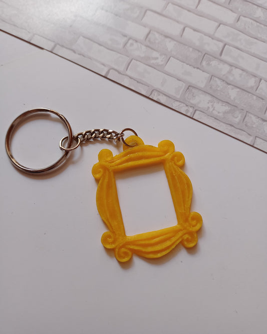 Yellow peephole frame keychain on white backdrop