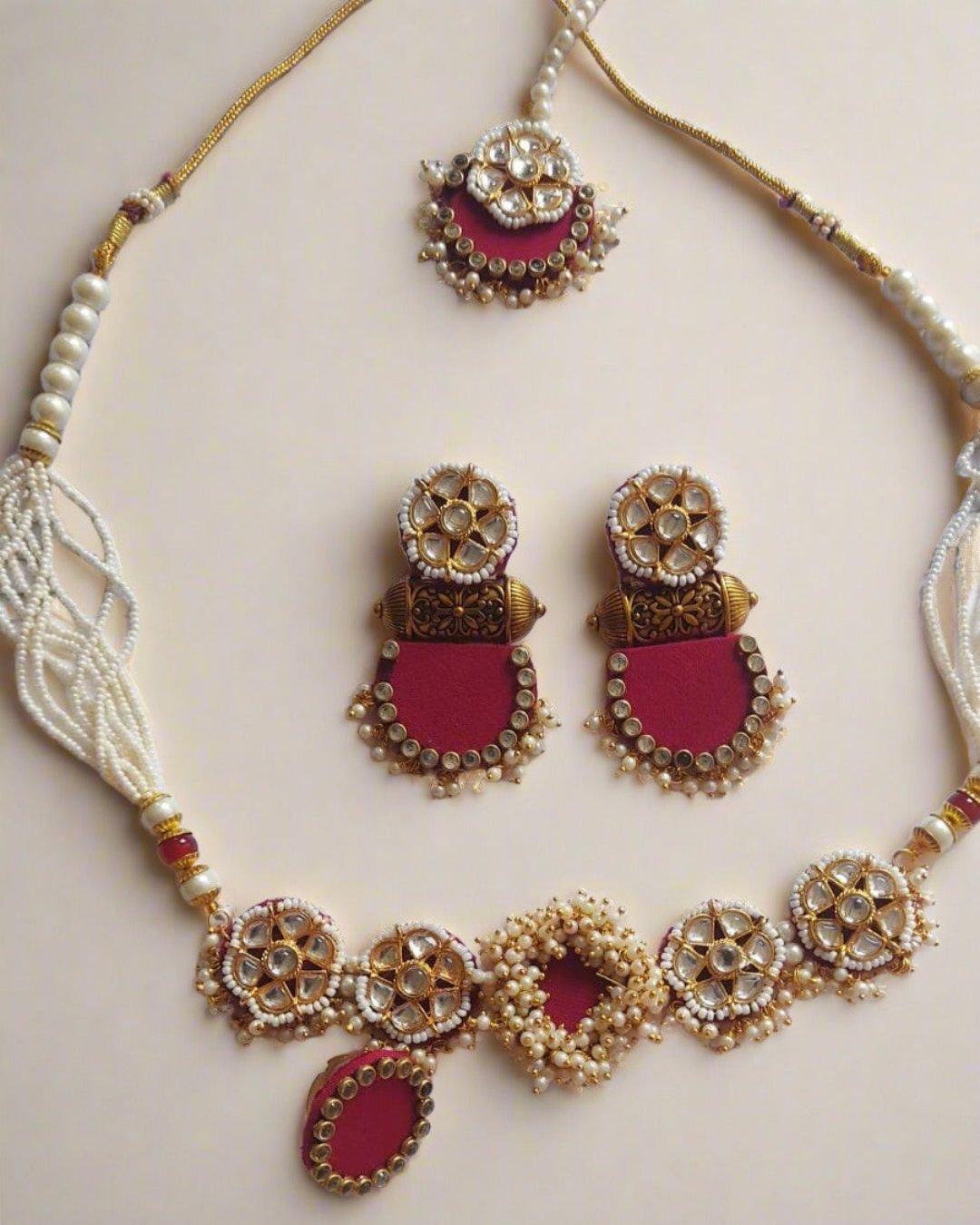 Pink and golden necklace, earrings ring and tika set with white beads and kundan