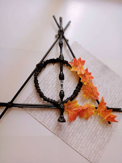 Harry potter deathly hallows sign, elder wand made with wood and decorated with orange leaves 