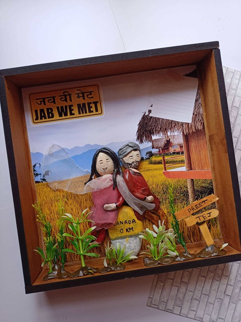 Punjabi couple caricature pebble art inside a wooden frame on white grey backdrop