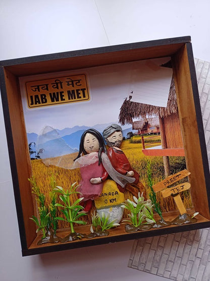 Punjabi couple caricature pebble art inside a wooden frame on white grey backdrop