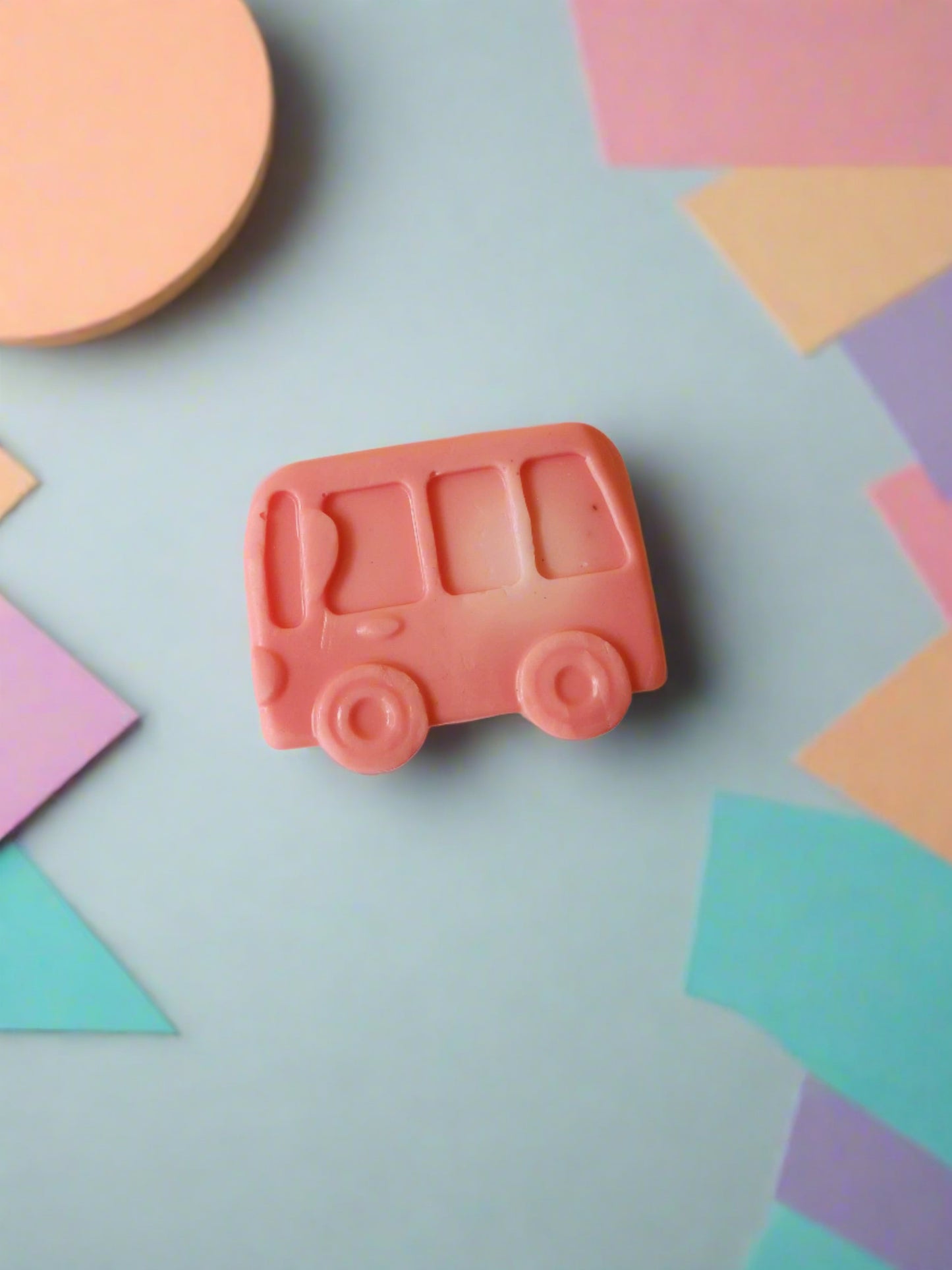 Pink bus shaped soap on white and blue backdrop