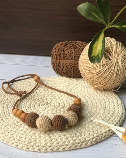 Light brown and beige round beads crochet necklace with wool balls at back