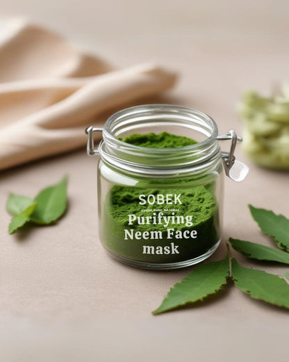 Sobek naturals neem face mask in glass jar with neem leaves around it on brown backdrop