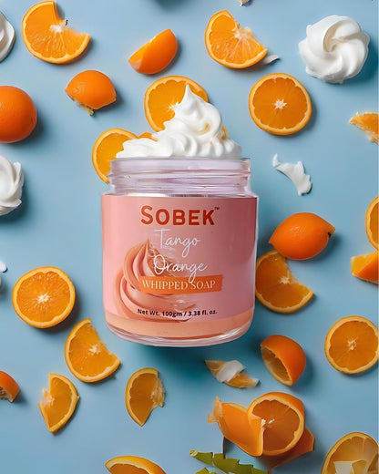 Sobek naturals orange whipped cream soap on blue backdrop with orange slices around