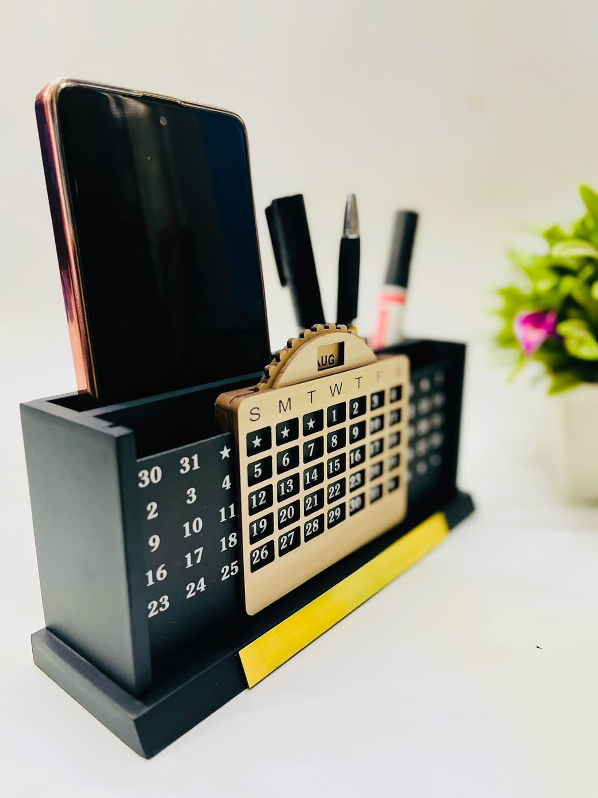 Black wooden pen and mobile stand with calendar, pens inside and a mobile on left side