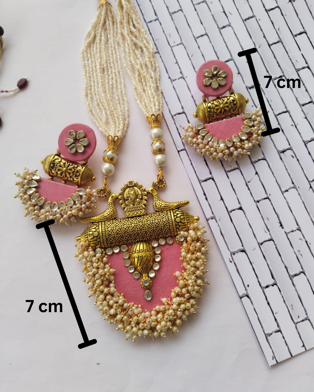 Pink and golden necklace set showing measurements on white backdrop