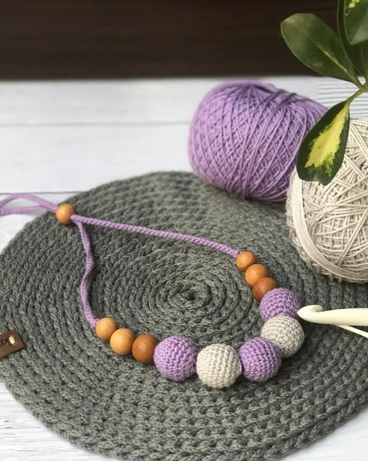 Purple and white crochet round beaded necklace on grey crochet base