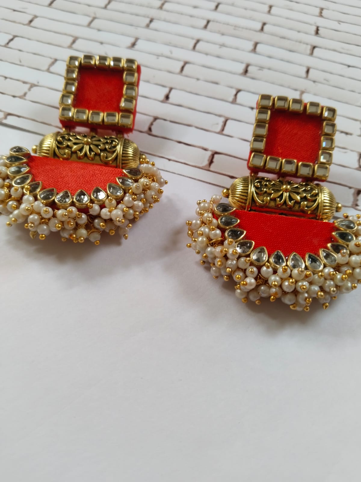 Bright red earrings with golden tabiz, white and golden beads and kundan