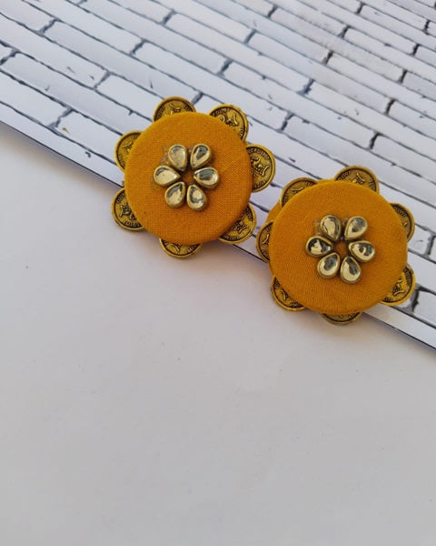 Yellow round studs with floral back and kundan front on white backdrop