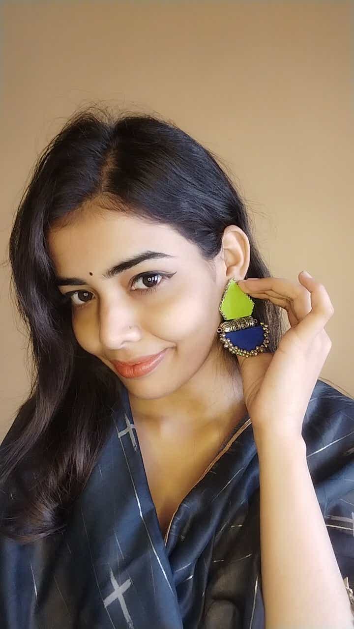 Indian girl smiling wearing green and blue earrings with silver tabiz and ghungroos