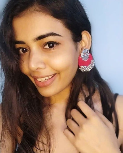Indian girl smiling wearing pink studs earrings with silver beads and charm
