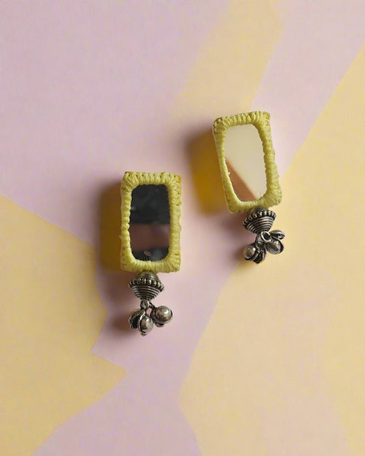 Yellow rectangular mirror earrings with ghungroos on white backdrop