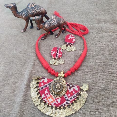 Red bandhani print big necklace with golden earrings and charms at bottom