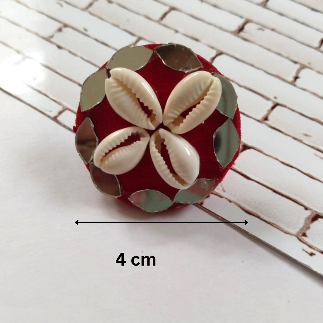 Red round ring with white shells on white backdrop showing measurements