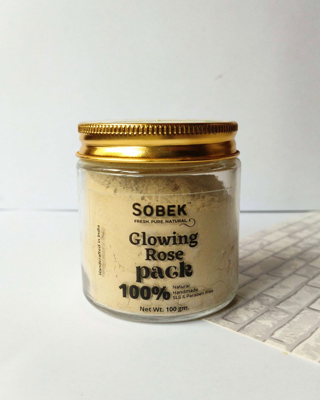 Glass jar with sobek glowing rose face pack on white backdrop