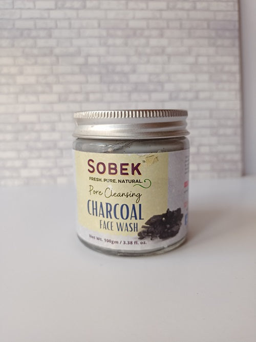 Glass jar on white backdrop with black charcoal face wash from sobek 