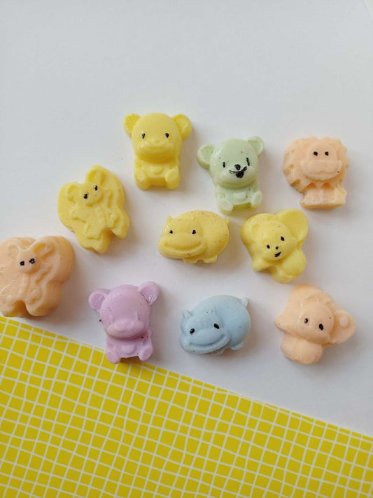Mini animals shaped colorful soaps on white yellow backdrop