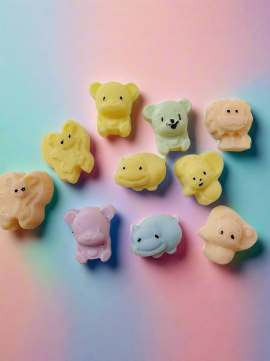 Mini animals shaped colorful soaps on white yellow backdrop