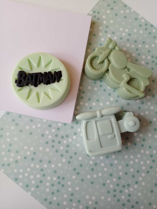 Car, batman and helicopter shaped green soaps on a white blue backdrop