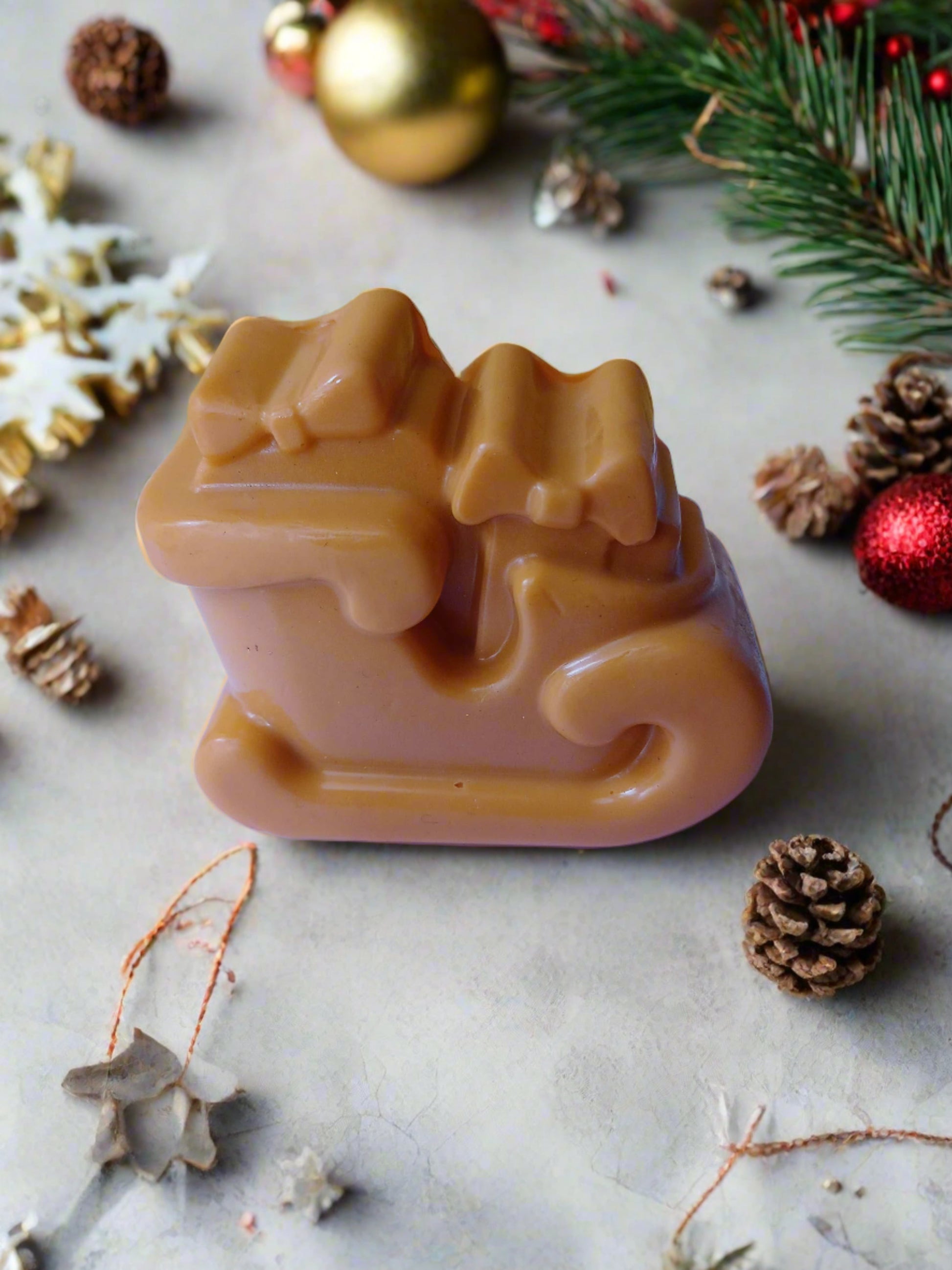 Orange santa's carriage shaped soap on white and multicolor backdrop